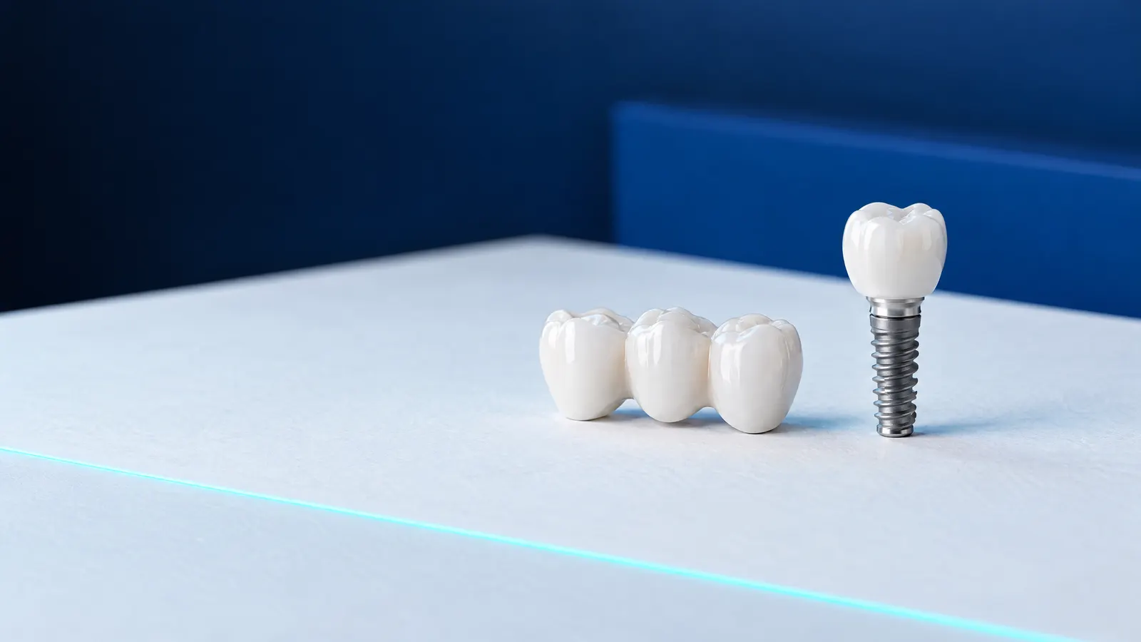 A three-unit ceramic bridge next to a titanium implant with a ceramic crown on a light surface